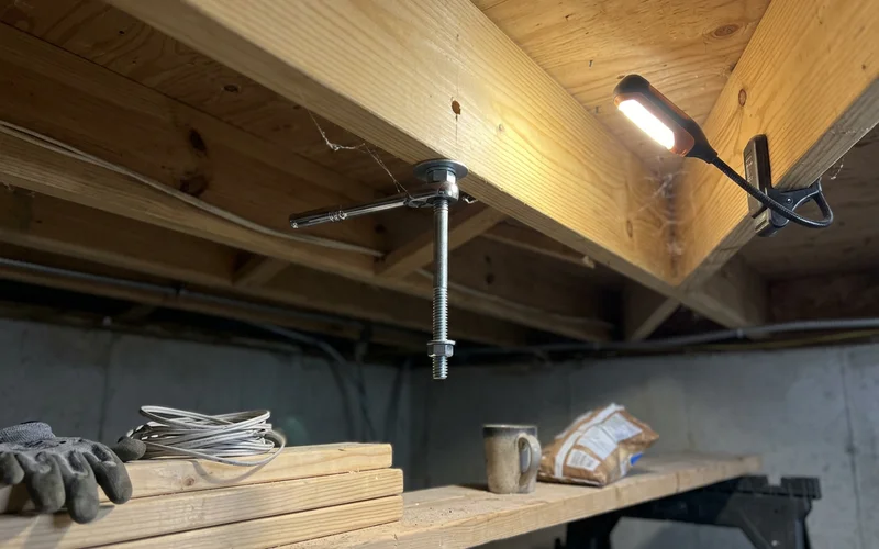 Newel anchor with a lag bolt into the floor joist, seen from below