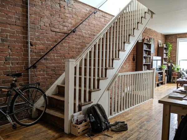 Condo loft staircase with dated pickets before glass railing