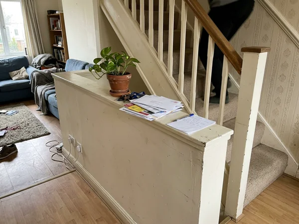 Drywall half wall beside stairs before the cable railing