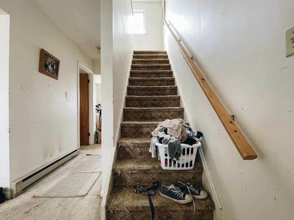 Carpeted straight staircase in a post-war bungalow before renovation