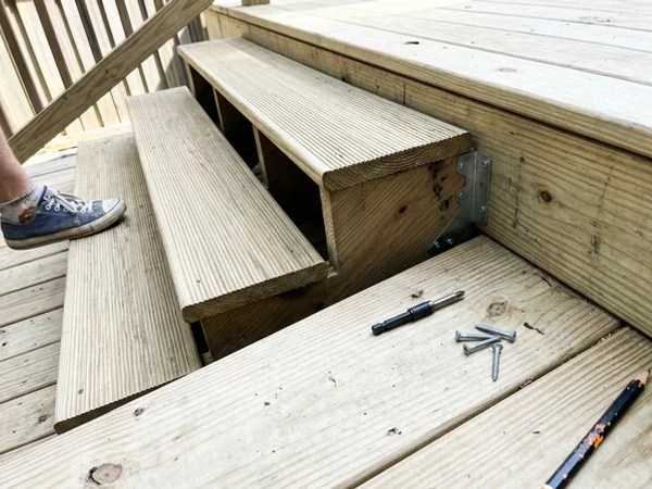 Close-up of grooved exterior treads and stringer hangers at the deck
