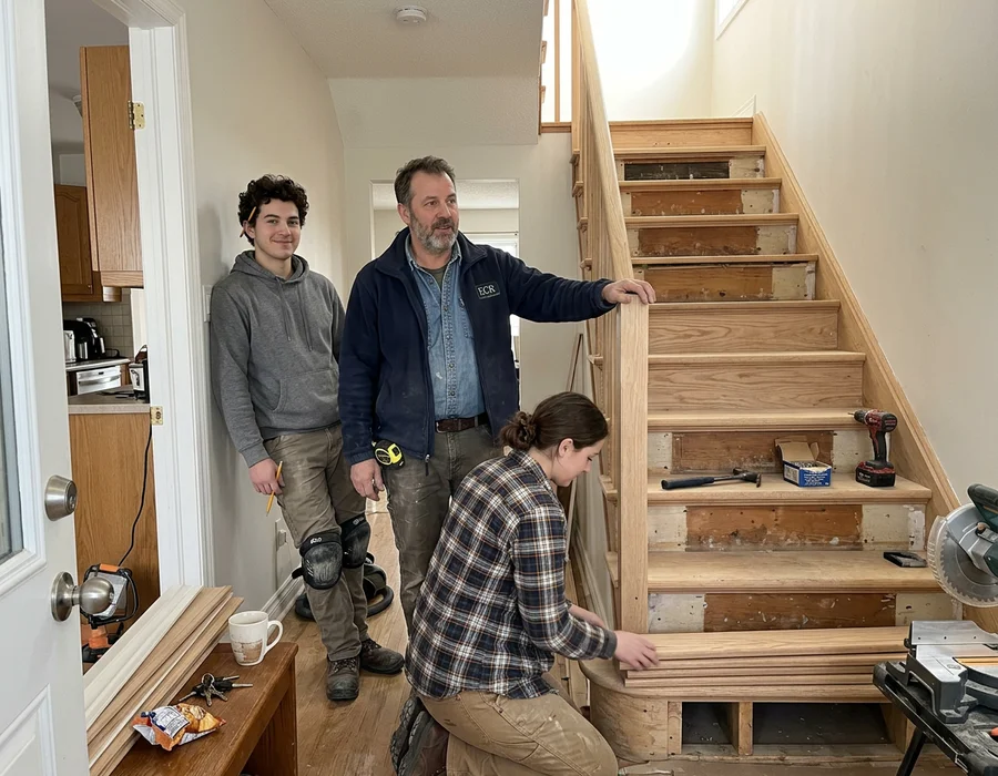 Andriy Kovalenko with his two-person crew beside a half-finished oak staircase