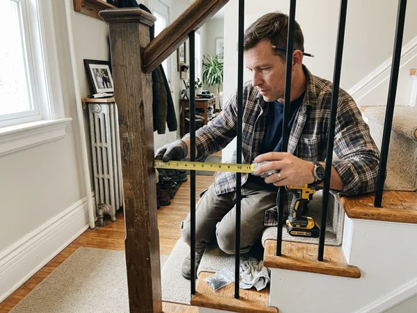 Installer checking baluster spacing against the 4-inch sphere rule