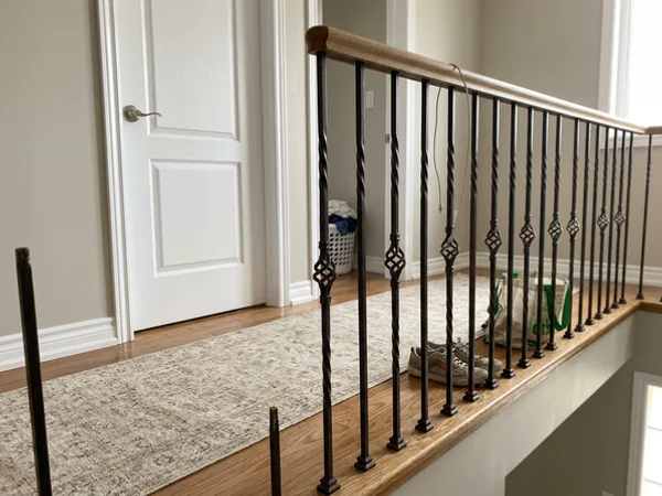 Oil-rubbed bronze double twist balusters along a landing guard